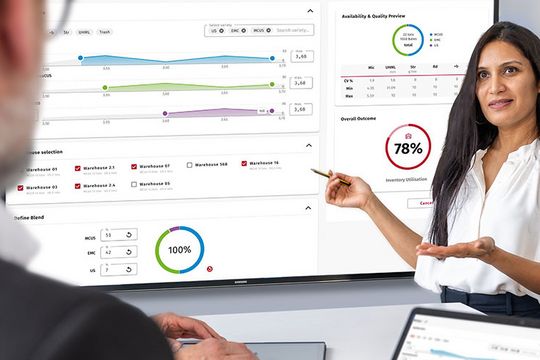 A woman is standing in front of a screen, explaining a man the Fiber Q values